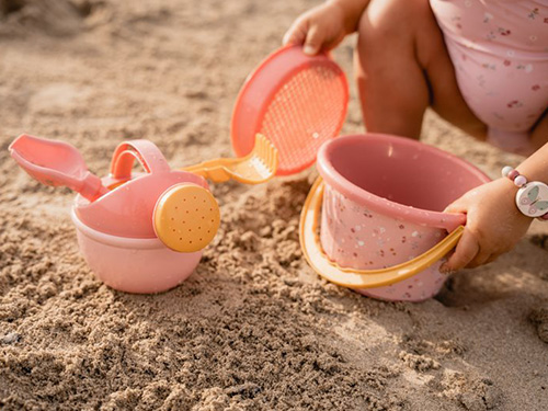 Κοριτσάκι παίζει στην άμμο με παιχνίδια