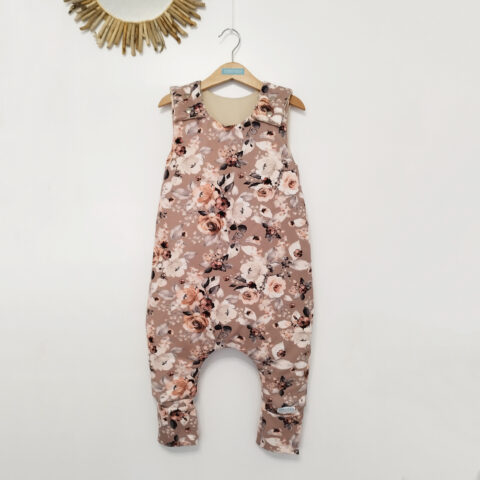 a floral sleeping bag in pink and white with legs and chunky straps with buttons