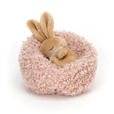 A soft brown bunny in his pink nest